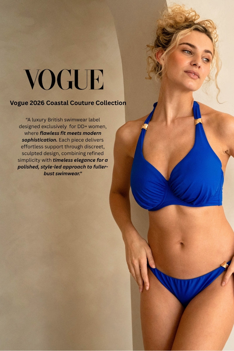 Woman wearing a luxurious blue fuller bust halter neck bikini with golden trims as featured in Vogue